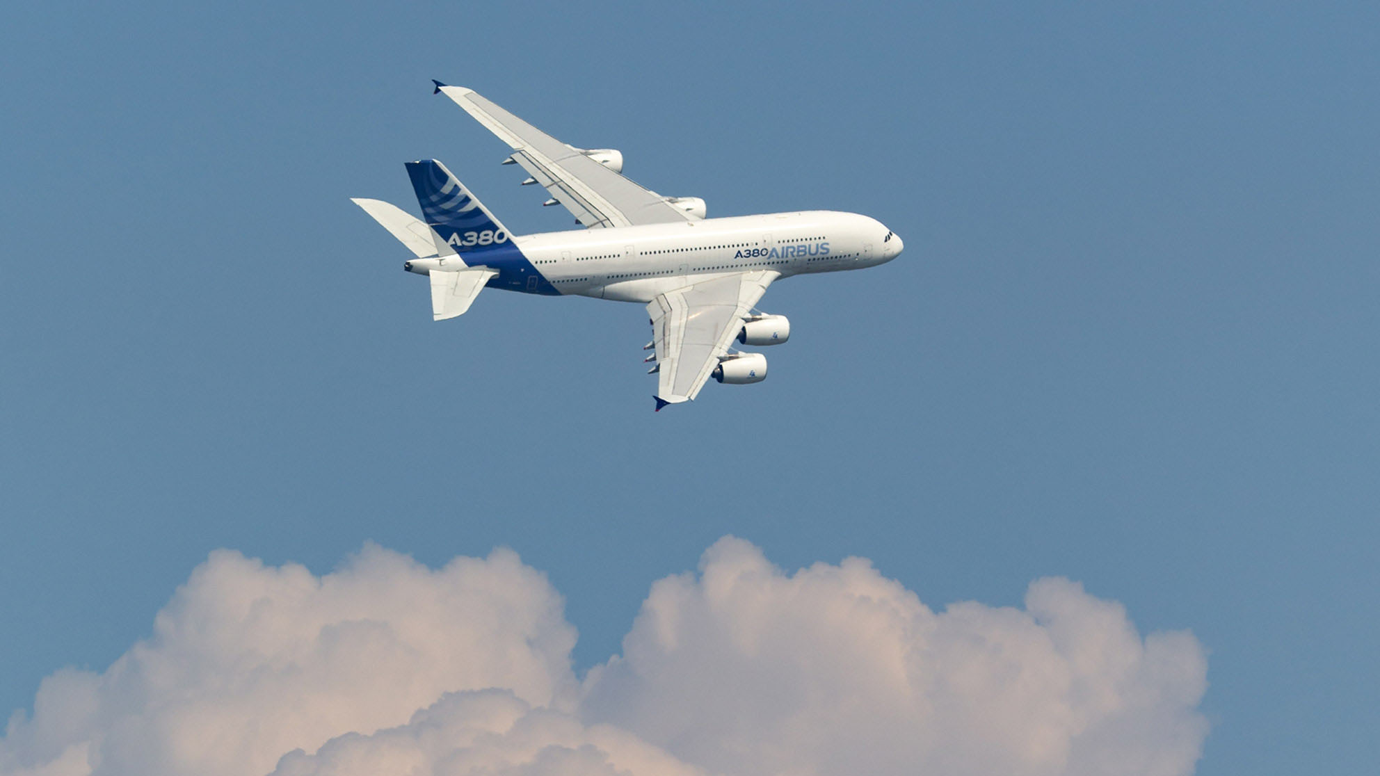 Airbus above clouds in front of a blue sky