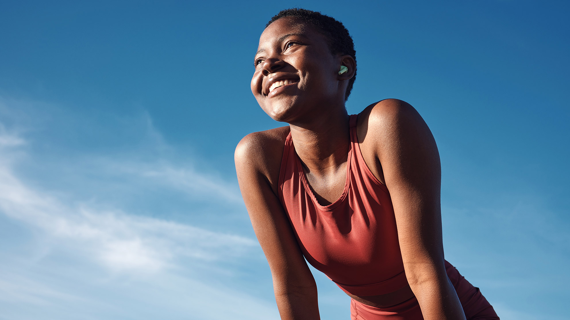 smiling woman doing sports in front of a blue sky